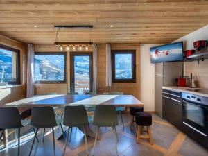 a kitchen and dining room with a table and chairs at Spacieux appart. 12 pers. au cœur de Val Thorens avec balcon et WiFi - FR-1-640-3 in Val Thorens +10 photos