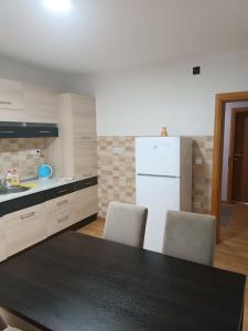 cocina con encimera negra y nevera blanca en 2BDR Apt with Balcony with view- Free Parking en Sarajevo