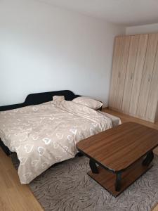a bedroom with a bed and a wooden table at 2BDR Apt with Balcony with view- Free Parking in Sarajevo