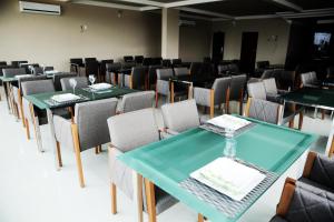 Hotel Vale Do Xingu في ألتاميرا: غرفة طعام مع طاولات وكراسي خضراء