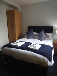 a bedroom with a bed with towels on it at Coasters Holiday Apartments in Skegness