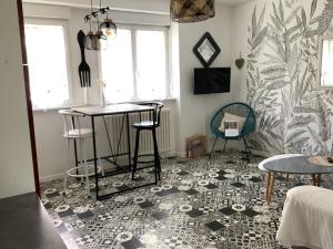 een woonkamer met een tafel en stoelen op een tegelvloer bij Les Bruyeres in Concarneau