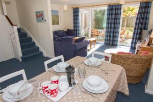 a dining room with a table and a living room at Sea Aster in Brancaster