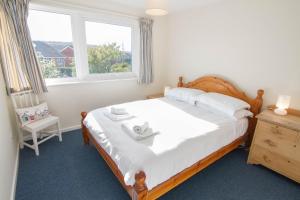 a bedroom with a large bed and a window at Sea Aster in Brancaster