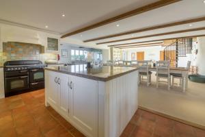 a kitchen with white cabinets and an island in the middle at Geddings Farm Barn in Ringstead