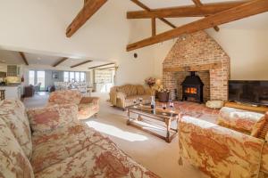 a large living room with a brick fireplace at Geddings Farm Barn in Ringstead