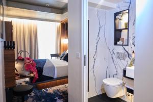um quarto de hotel com uma cama e uma casa de banho em CARD Hôtel em Paris