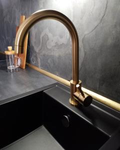 a kitchen sink with a gold faucet on a counter at Gallery Room 01 in Bielefeld