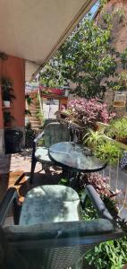 un patio con mesa, sillas y plantas en Hostel Lena-Mostar, en Mostar