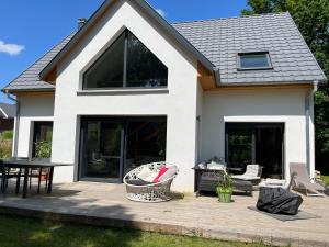 ein Haus mit großen Fenstern und einer Terrasse in der Unterkunft Magnifique maison cadre bucolique in Walbach