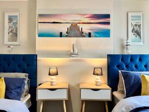 a bedroom with two beds and two tables with lamps at Beach Vibes in Southend-On-Sea by Artisan Stays I Leisure or Business I Free Parking I Sleeps 5 in Southend-on-Sea