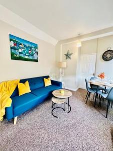 a living room with a blue couch and a table at Beach Vibes in Southend-On-Sea by Artisan Stays I Bank Holiday Offer I Free Parking in Southend-on-Sea
