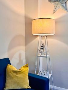 a lamp with a yellow pillow next to a blue couch at Beach Vibes in Southend-On-Sea by Artisan Stays I Free Parking I Bank Holiday Offer in Southend-on-Sea