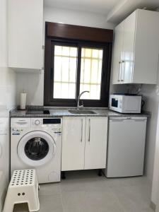 een keuken met een wasmachine en een wastafel bij BENALMADENA ALOHA PLAYA BEACH LOFT in Benalmádena