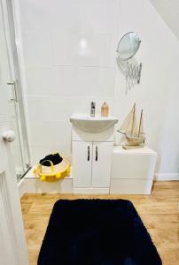 a bathroom with a sink and a toy boat on the floor at Beach Vibes in Southend-On-Sea by Artisan Stays I Free Parking I Sleeps 5 I Families or Contractors in Southend-on-Sea