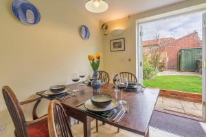 a dining room with a table and chairs and a window at 1 Honeymoon Row in Wells next the Sea