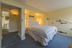 a bedroom with a large bed and a bathroom at 1 Honeymoon Row in Wells next the Sea