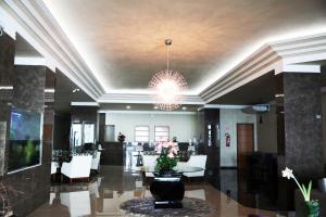 a lobby with a chandelier and tables and chairs at Hotel Vale Do Xingu in Altamira