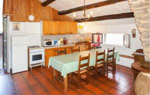 a kitchen with a table and chairs and a refrigerator at 2 Bedroom Amazing Home In Olargues in Olargues