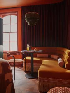 Cette chambre comprend un canapé et une table avec des chaises. dans l'établissement Ember Locke Kensington, à Londres