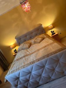 a bedroom with a large bed and a chandelier at Vienna Citycenter+Terrace+Parking in Vienna