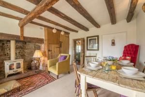 a living room with a table and a fireplace at Brooke Cottage in Little Walsingham