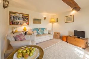 a living room with a couch and a tv at Brooke Cottage in Little Walsingham