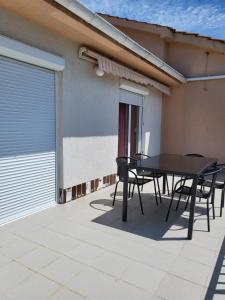 a patio with a table and chairs in front of a house at Apartment Grabar in Cres +32 photos