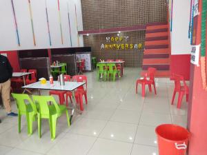 a restaurant with red and green tables and chairs at OYO Sgr Hotel in Hastināpur