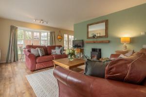 a living room with a couch and a table at Forge Cottage in Thornham