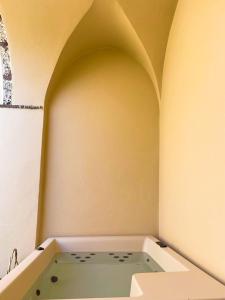 a bath tub sitting in a room with an arch at AENAON ESTATE 1896 by K&K in Pirgos