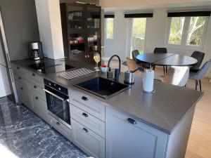 a kitchen with a counter with a sink and a table at Casa Blanca in Strandbaden