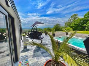 a patio with a swimming pool and an umbrella at Feriendomizil Schleich am Steinriegl in Bad Gleichenberg