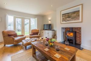 a living room with a table and a fireplace at Anchorage in Brancaster