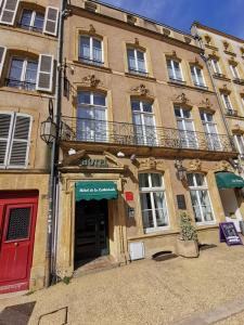a building with a red door and a balcony at Hôtel de la Cathédrale Metz in Metz