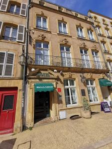 - un bâtiment avec une porte rouge et un balcon dans l'établissement Hôtel de la Cathédrale Metz, à Metz