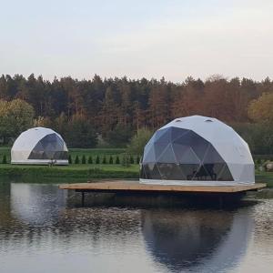 two domed tents on a dock on a body of water at Greenery Kupolai 