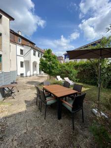 einen Holztisch mit Stühlen und einem Sonnenschirm in der Unterkunft Nisay Home - 3 Room Apartment - Nr3 in Ludwigsburg