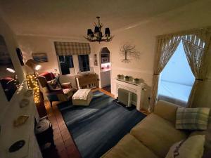 sala de estar con sofá y chimenea en Todday Snug Self Catering Studio, en Ersary