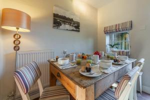 a dining room table with chairs and a wooden tableablish at Froggy Cottage in Thornham