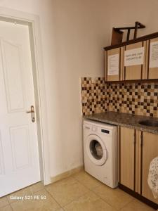 a laundry room with a washing machine and a white door at Salda gölü in Yeşilova
