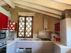 eine Küche mit einem Herd, einem Waschbecken und einem Fenster in der Unterkunft Luxuryloft La Guarnigione in Valeggio sul Mincio