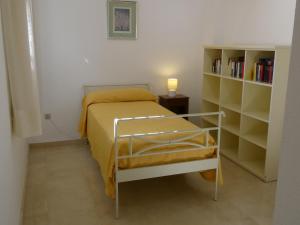 una piccola camera con letto e libreria di GOLF Y PLAYA EN SAN JUAN ad Alicante
