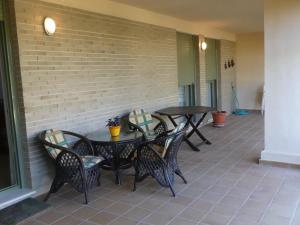 un patio con tavoli, sedie e un muro di mattoni di GOLF Y PLAYA EN SAN JUAN ad Alicante