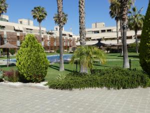 un complejo con piscina y palmeras en GOLF Y PLAYA EN SAN JUAN, en Alicante