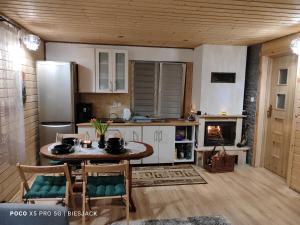 a kitchen with a table and a fireplace at Chata DUDZIAKÓWKA in Werlas
