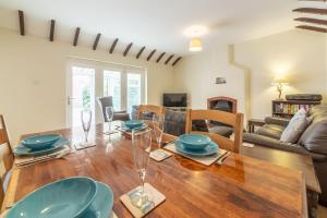 a dining room and living room with a wooden table at Sea Wind in Brancaster