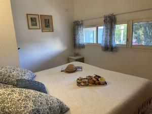 Un dormitorio con una cama con una bandeja de comida. en Appartement Fréjus, 2 pièces, 4 personnes - FR-1-226A-122, en Fréjus