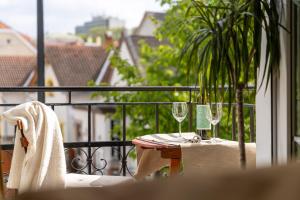 a table with two wine glasses on a balcony at Villa Lucia in Hévíz