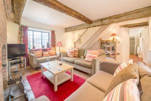 a living room with a couch and a tv at Angel Cottage in Little Walsingham